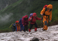 悪天候の中、北アルプスを行く中高年登山ツアー