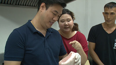 タイ国内で仕入れた豚ロース肉の質をチェックする「みそかつ矢場とん（タイランド店）」店長ピンさんとシェフのトウさん